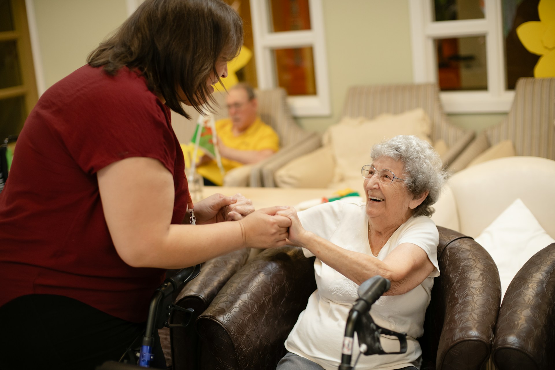 Care worker holding the hand of an elderly woman