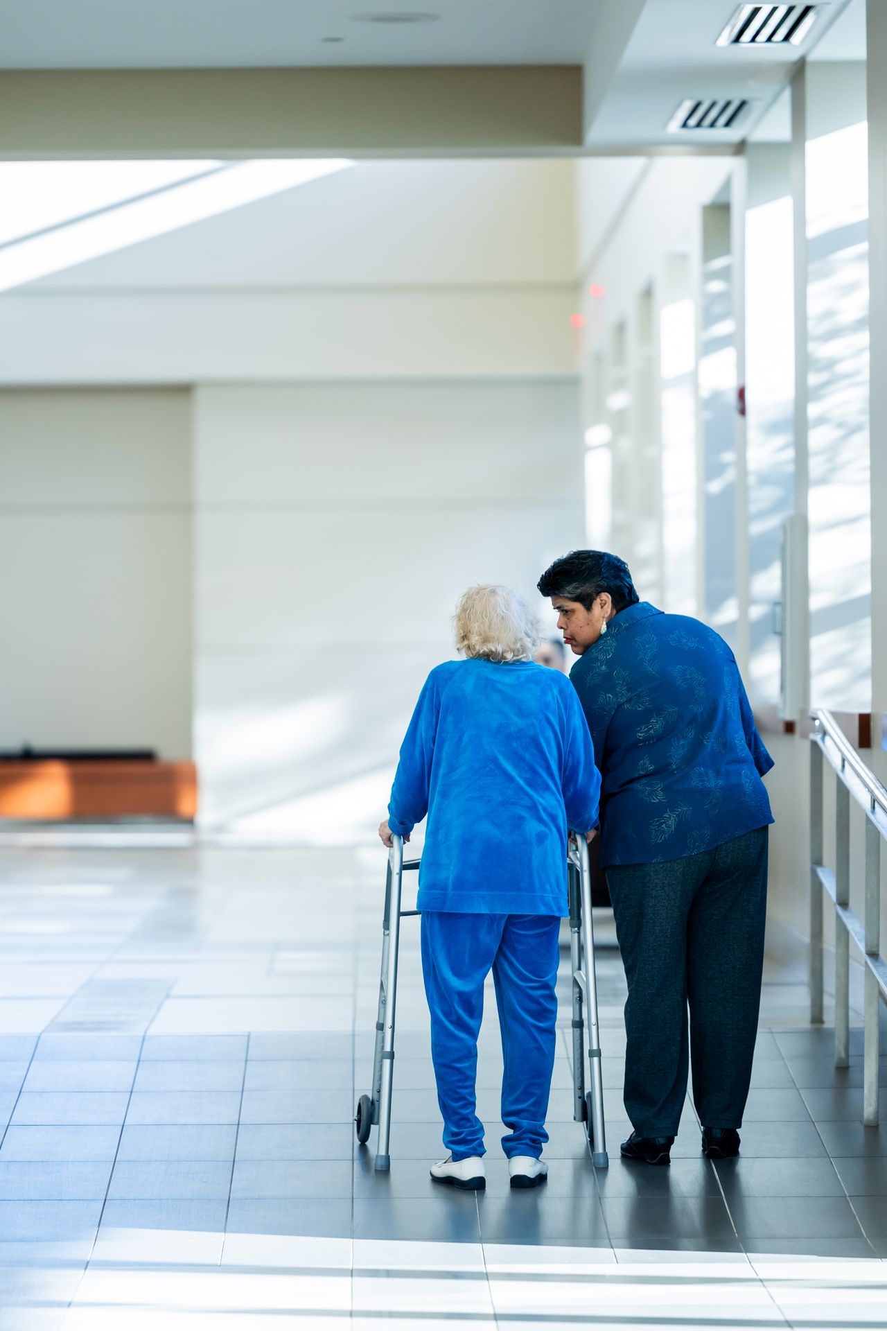 Nurse supporting an elderly woman